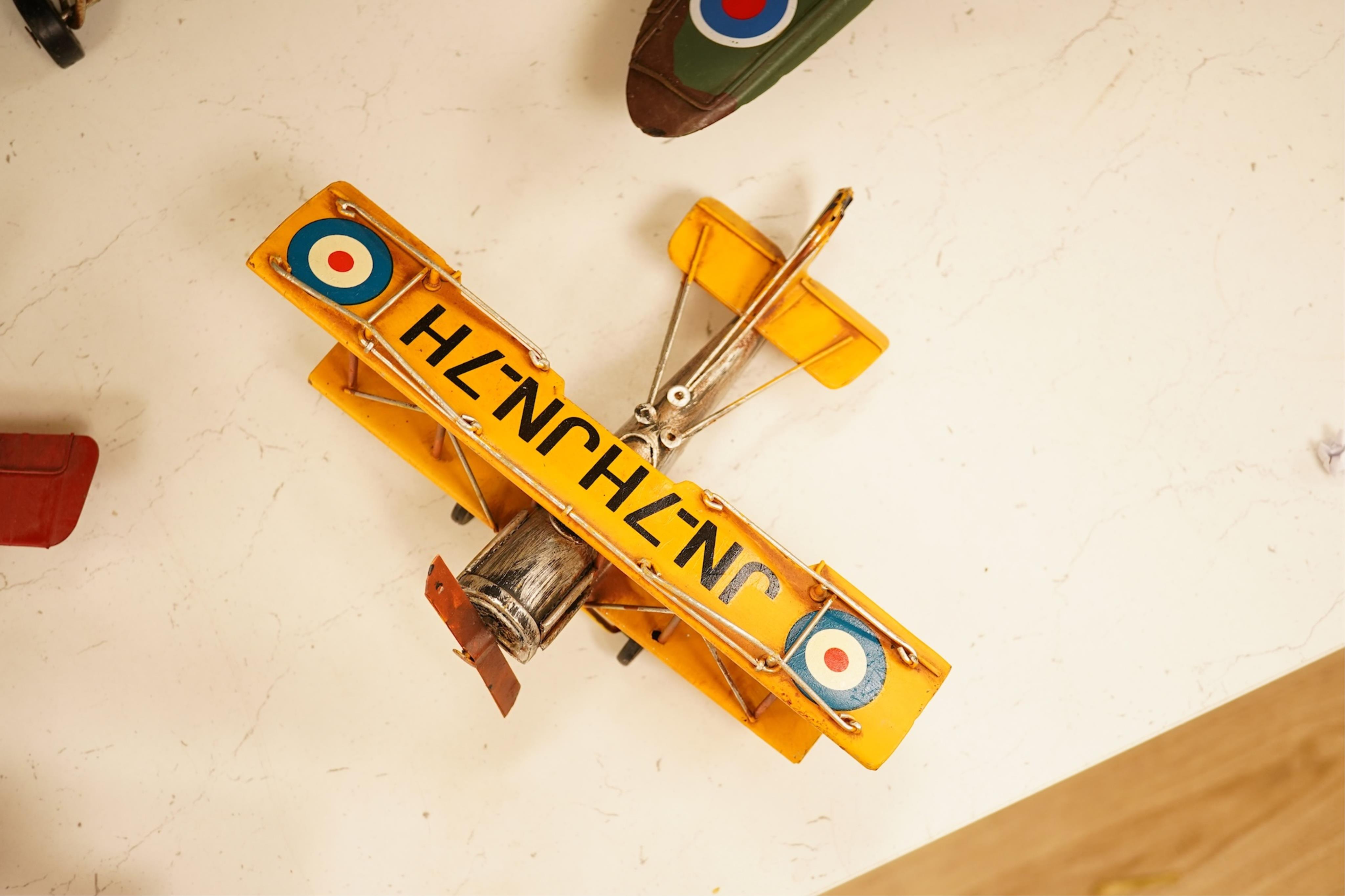 Five decorative metal models of military aircraft, including two Supermarine Spitfires, two First World War, British bi-planes, a German Albatros D.III bi-plane, and a wooden model of RMS Queen Mary, hull 77cm long